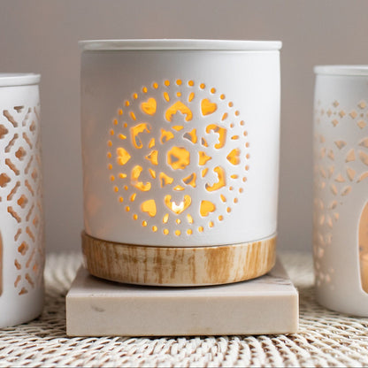 Decorative candle holder with intricate cut-out design on a neutral background