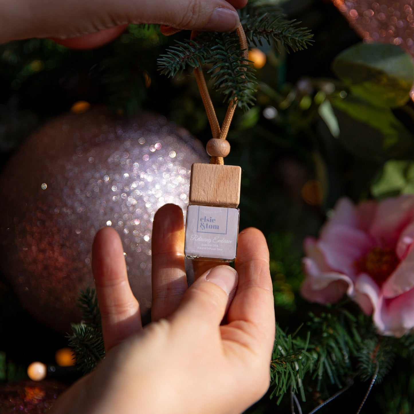Mini Aromatherapy Daily Rituals diffuser being placed on a christmas tree as a decoration.