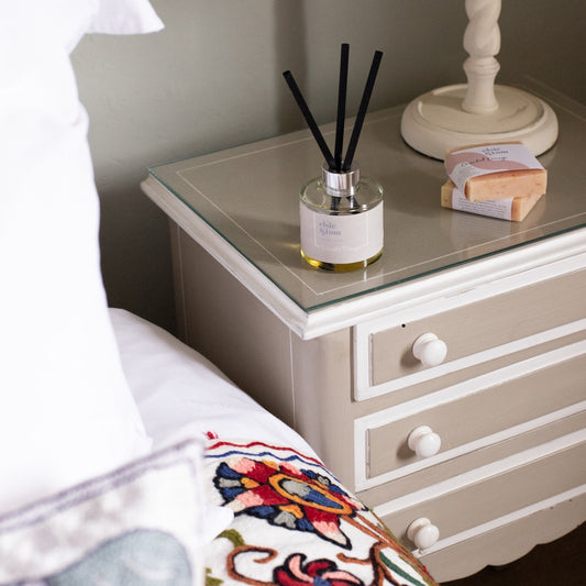 Oriental Orange Essential Oil Scented Daily Rituals Reed Diffuser on a bed side table in a luxury bedroom setting. by Elsie and Tom.
