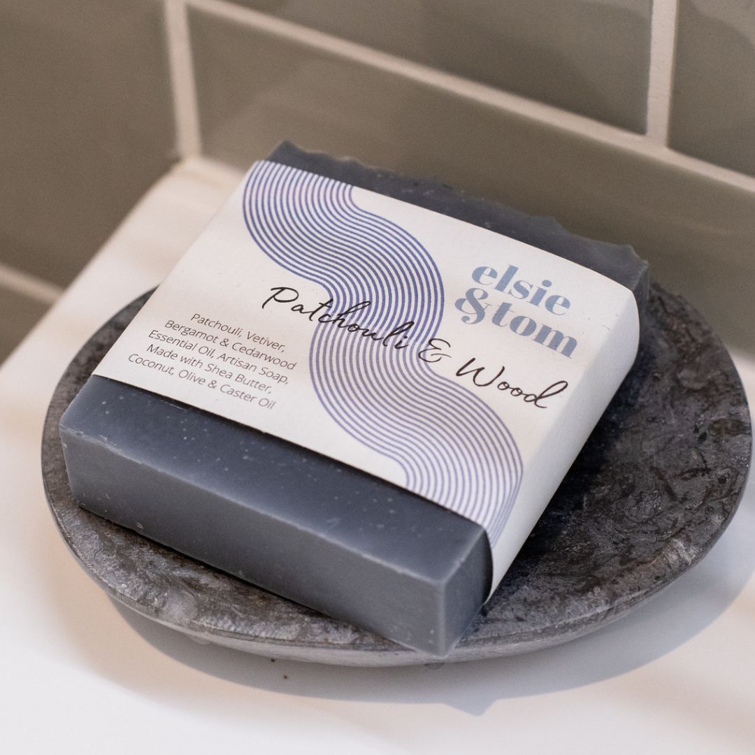 Bar of Patchouli & Wood soap with packaging on a stone surface, featuring the brand 'elsie & tom'.